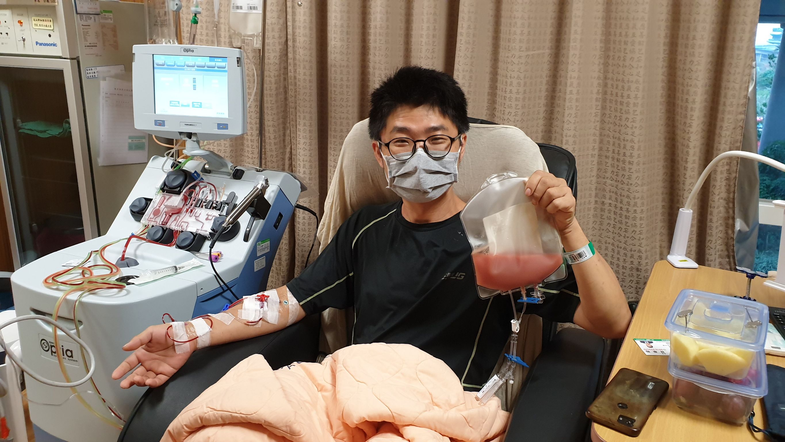 賴中仁於醫院住院完成骨髓捐贈手持血袋之現場照